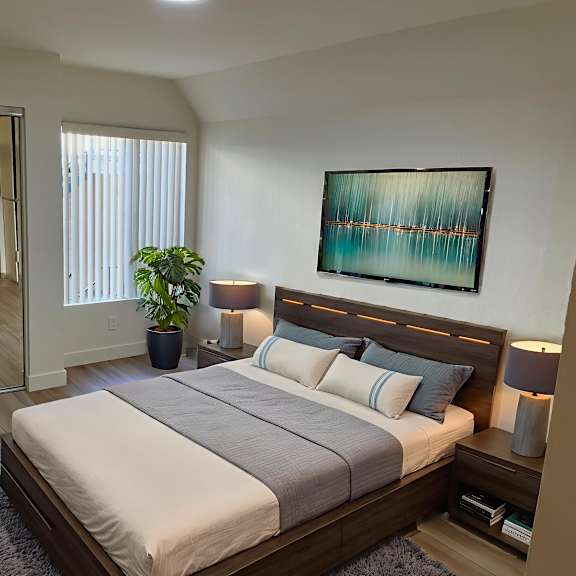 a bedroom with a large bed and a painting on the wall.