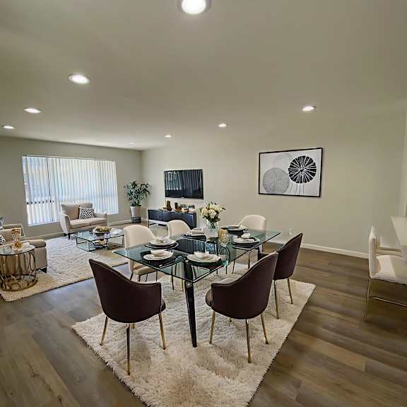 a modern dining room with a glass table and chairs.