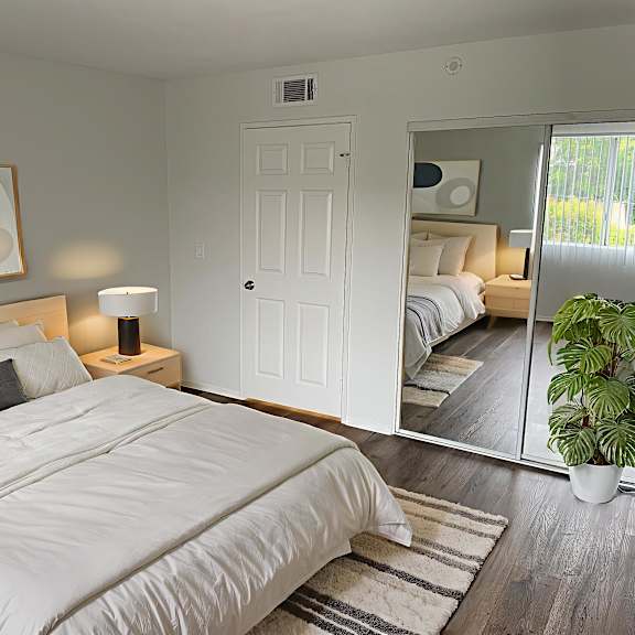 a bedroom with a large bed and a mirror on the wall.