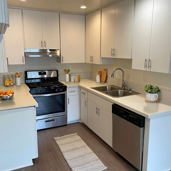a modern kitchen with white cabinets and stainless steel appliances.