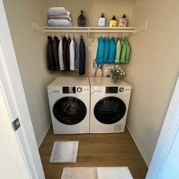 a laundry room with two washing machines and a shelf with towels and detergent.
