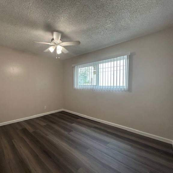 a room with a ceiling fan and a window with blinds.