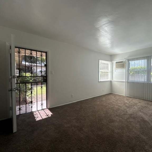 a room with a carpeted floor and a sliding glass door.