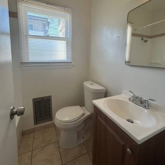 a white toilet sits next to a sink in a small bathroom.