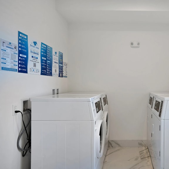 two washer and dryers in a laundry room with white walls