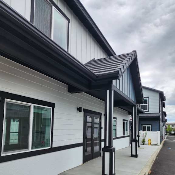 a white building with black trim and a black awning.