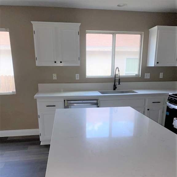 a kitchen with white countertops and white cabinets