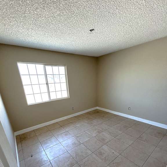 a room with a window and tile flooring.