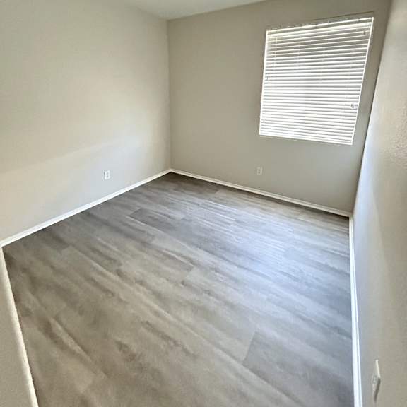 a room with a window and wooden flooring.