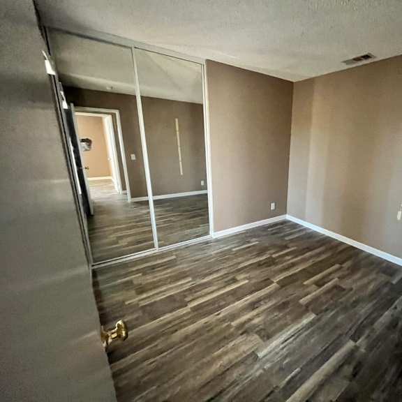 a room with wooden flooring and a glass door.