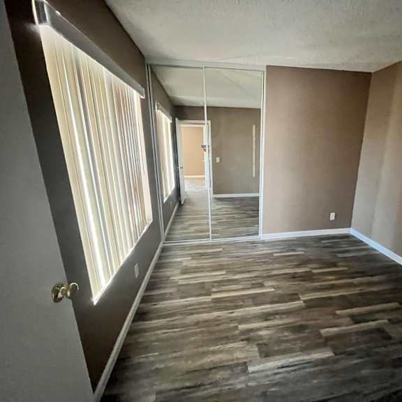 a room with wooden flooring and a door at the end.