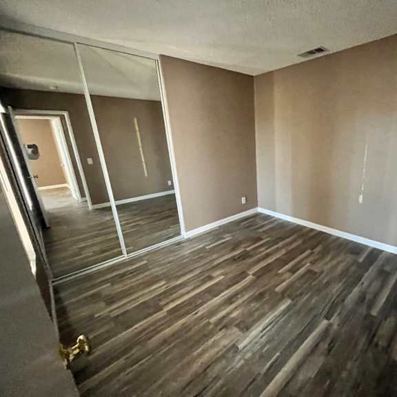 a room with wooden flooring and glass doors.