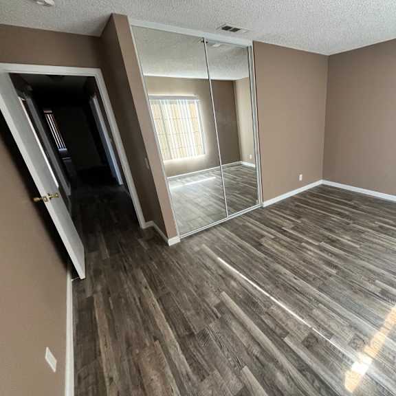 a room with wooden flooring and a sliding glass door.