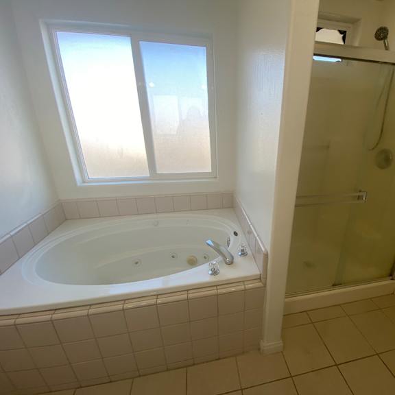 a white bathroom with a tub and shower.