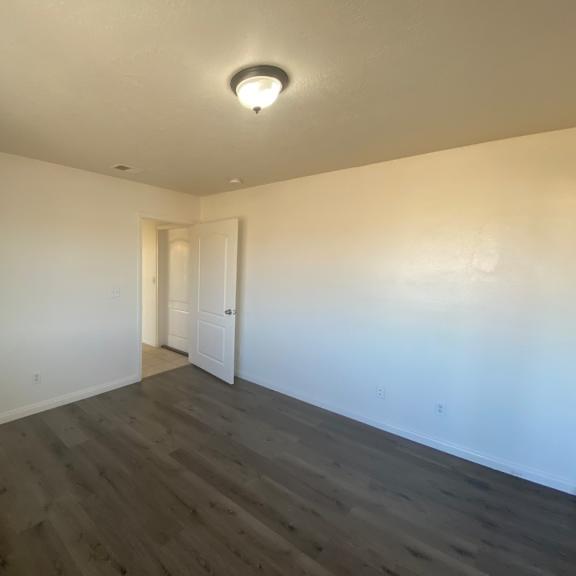 a room with a wooden floor and a white door.