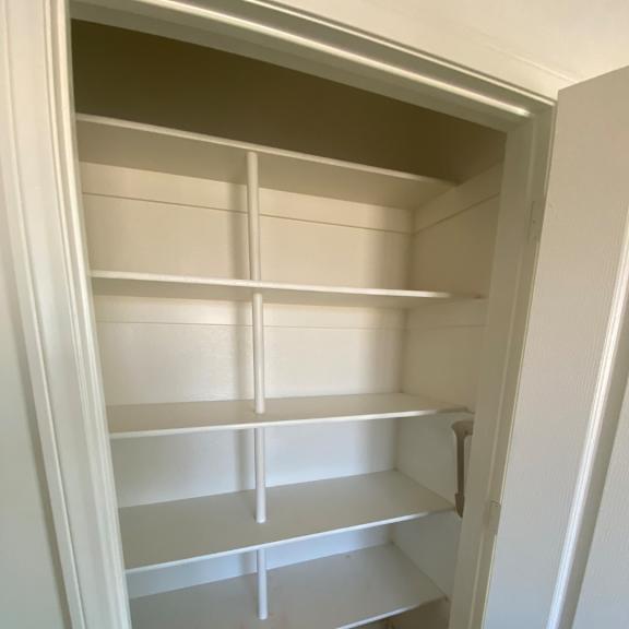a white cabinet with shelves and drawers is open.