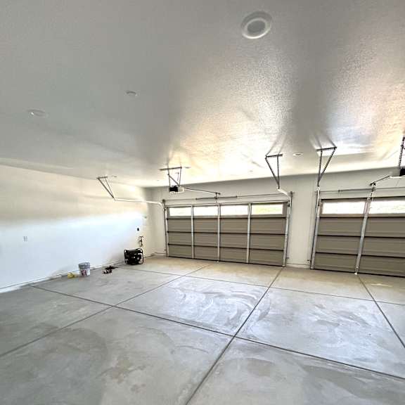 a garage with a concrete floor and two overhead lights.