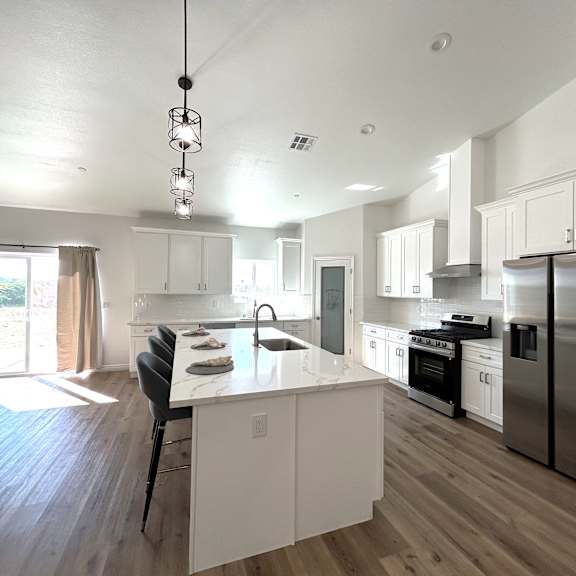 a modern kitchen with white cabinets and stainless steel appliances.