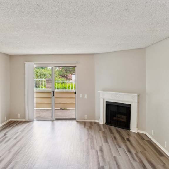 an empty living room with a fireplace and a window