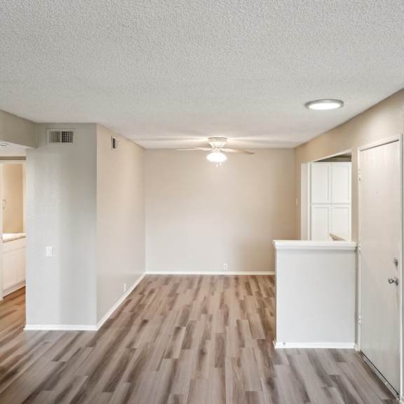 an empty living room with wood flooring and white walls