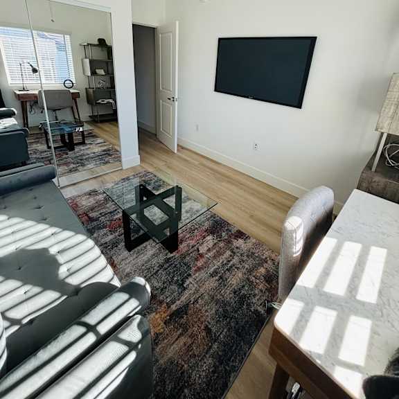 a living room with a black flat screen tv mounted on the wall.