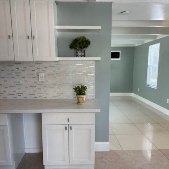 a kitchen with white cabinets and a white counter top