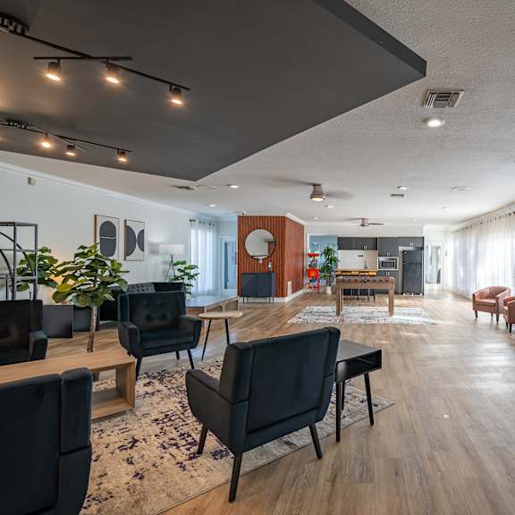 a living room with black chairs and a wooden floor. at red bay apartment complex, jacksonville, fl, 32211