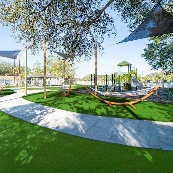 a playground with a slide and a swing set. at red bay apartment complex, jacksonville, fl, 32211