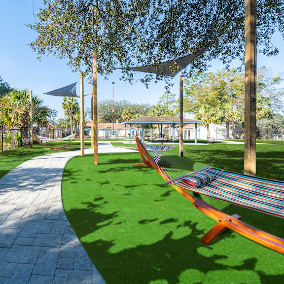 a park with a hammock between two trees. at red bay apartment complex, jacksonville, fl, 32211