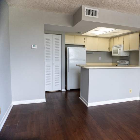 an empty living room with a kitchen with a refrigerator and  at bella lago vista, west palm beach, fl, 33401