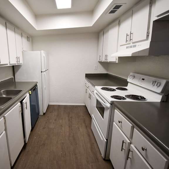 an empty kitchen with white cabinets and appliances and a sink at red bay apartment complex, jacksonville, fl, 32211