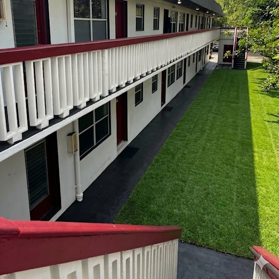 a long white building with red trim and a black roof.