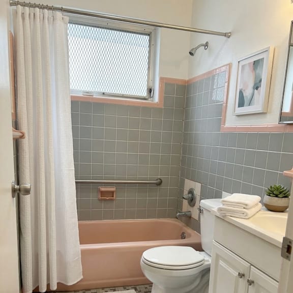 a bathroom with a toilet, tub, and sink.