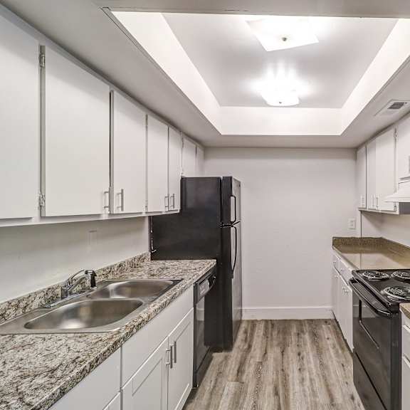 a kitchen with white cabinets and black appliances at red bay apartment complex, jacksonville, florida