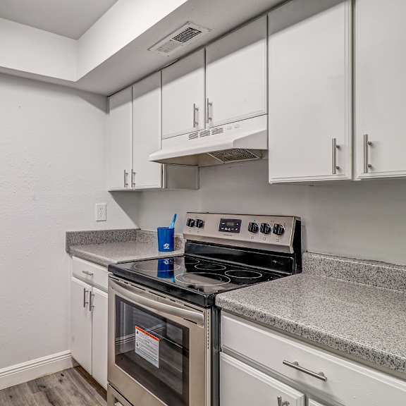 a kitchen with white cabinets and stainless steel appliances at red bay apartment complex, florida, 32211