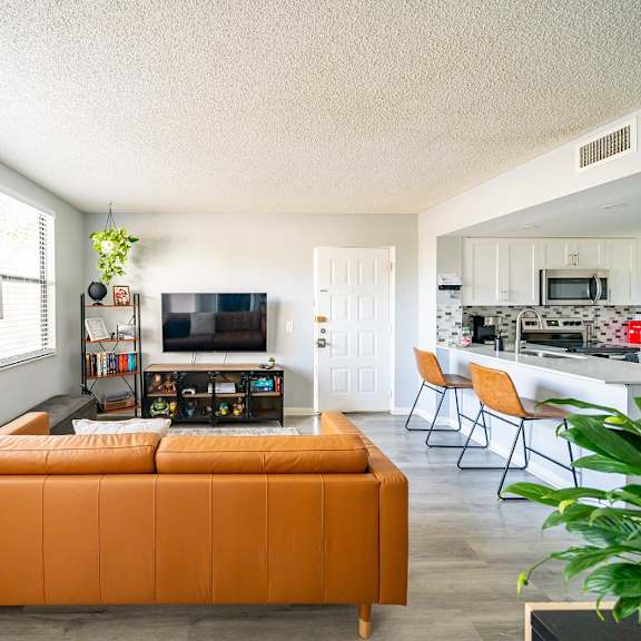a living room with a couch and a kitchen with a table and chairs at bella lago vista, west palm beach, florida