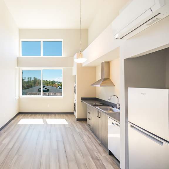an empty room with a kitchen and a window