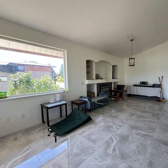 a large, empty living room with marble flooring and white walls.