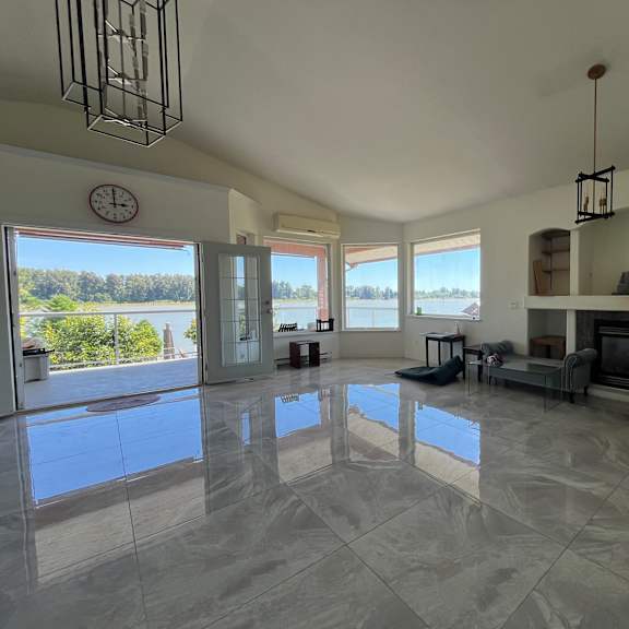 a living room with a fireplace and a large window overlooking a lake.