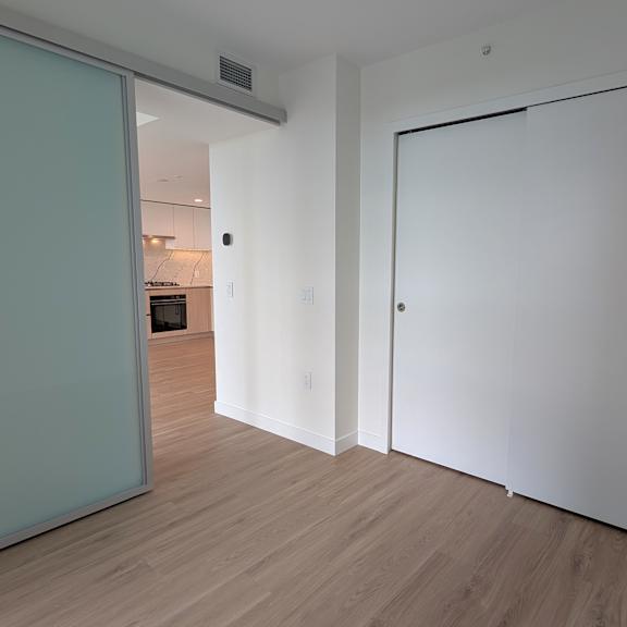 a white door is in a room with a wooden floor.