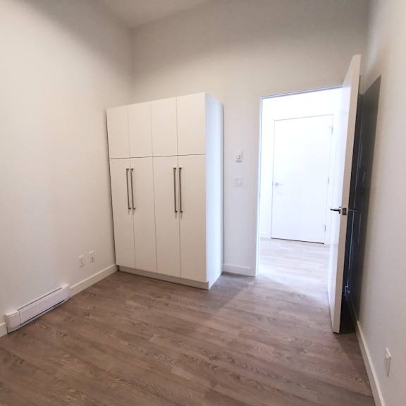 a room with a white door and a black refrigerator.