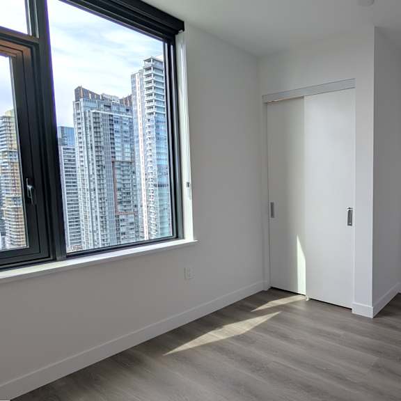 a room with a large window and a view of a city skyline.