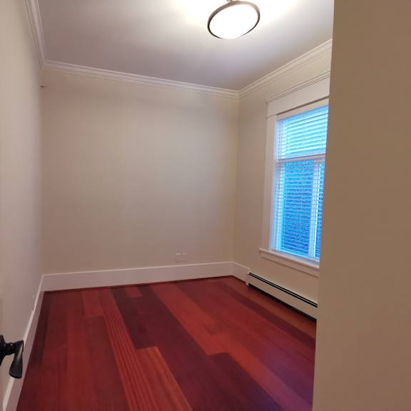 a room with a red floor and a window with blinds.