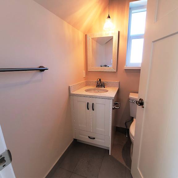 a small white bathroom with a sink, mirror, and toilet.