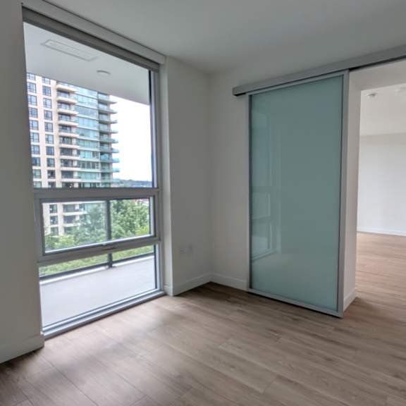 a room with a sliding glass door leading to a balcony.
