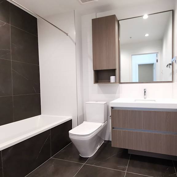 a modern bathroom with a toilet, sink, and bathtub.