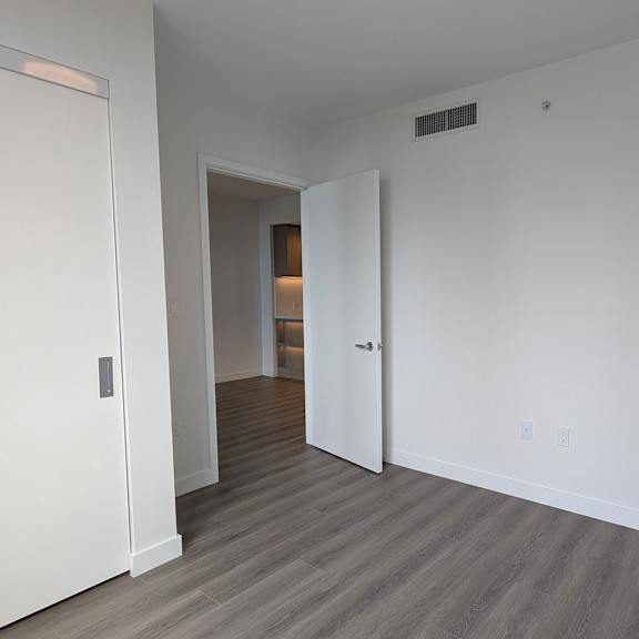 a room with a white door and a grey floor.