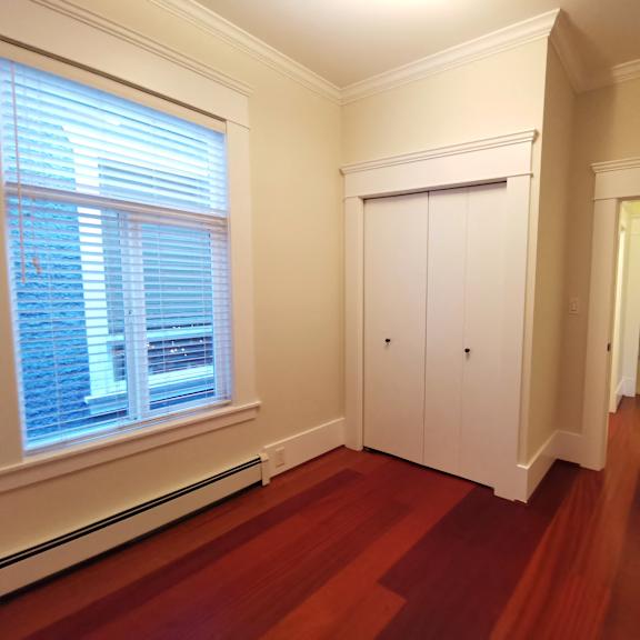 a hallway with a wooden floor and white walls.