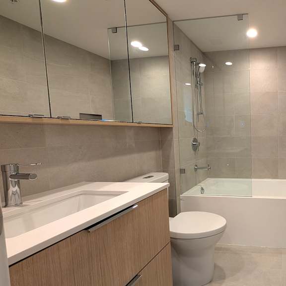 a modern bathroom with a glass shower enclosure and a white toilet.