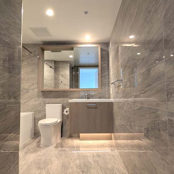 a bathroom with a toilet, sink, and mirror.